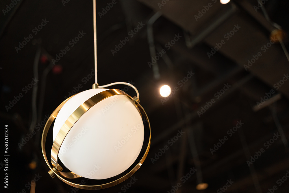 warm lights hanging from ceiling in local restaurant. Close-up shot with blurred background. Negative copy space warm lights hanging from ceiling in local restaurant. Close-up shot with blurred background. Negative copy space