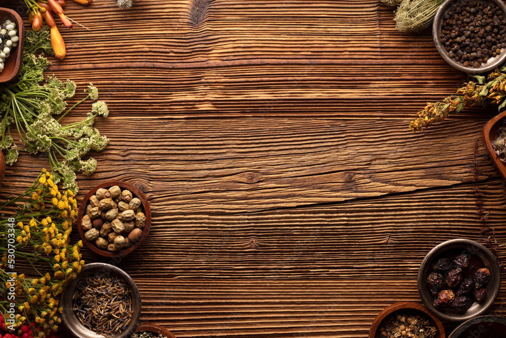 Natural medicine background. Assorted dry herbs in bowls, mortar and plants on rustic wooden table. Natural medicine background. Assorted dry herbs in bowls, mortar and plants on rustic wooden table.