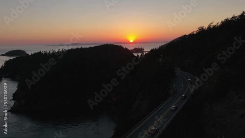 Aerial shot of the sun setting over Deception Pass as cars drive onto Fidalgo Island. photo