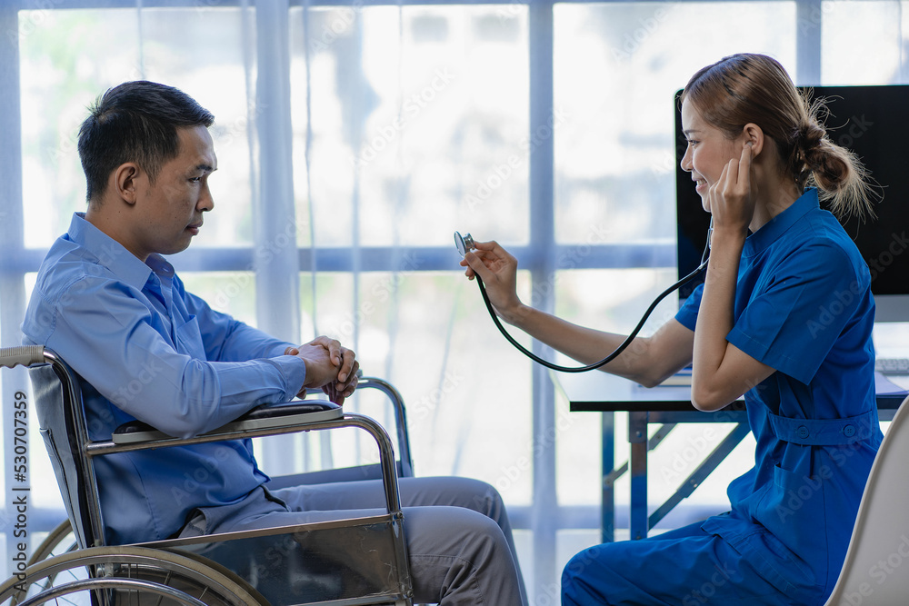 An Asian female doctor checks the heart rate of a male patient in a ...