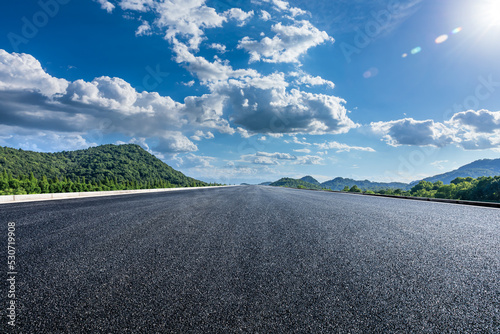Straight asphalt road and green mountain nature background © ABCDstock