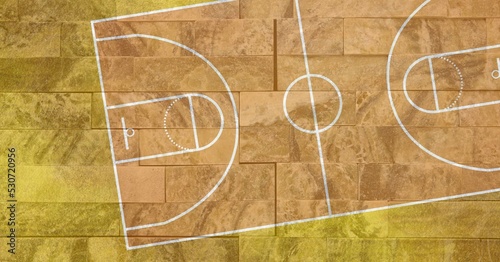 Composition of brown and yellow basketball court overhead view over textured brick wall background