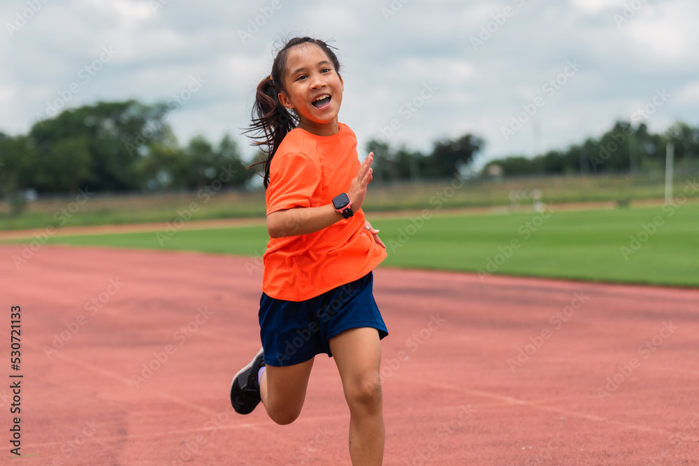 Girl practicing on her running technique in the track