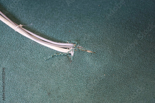 Installation of electrical cables that come out of the green carpet.