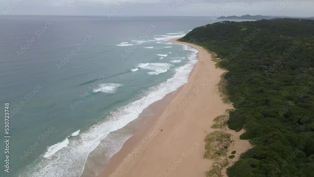 Beach And Sea Panorama with approaching drone as waves hit the sand at Ponta do Ouro , Mozambique Beach And Sea Panorama with approaching drone as waves hit the sand at Ponta do Ouro , Mozambique