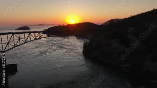 Wide orbiting aerial view of Deception Pass State Park at sunset. photo