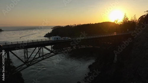Aerial shot of a truck hauling an RV over Deception Pass Bridge during sunset. photo