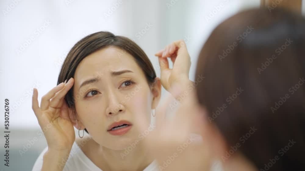 60p　洗面所で薄毛に悩むミドル女性（髪の毛・白髪）