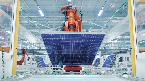 Orange Industrial Robot Arm Grabs and Moves Solar Panels on Conveyor. Automated Manufacturing Facilit. Production Line at Modern Bright Factory.