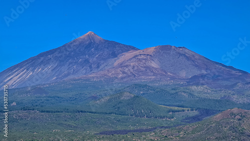 Scenic view on volcano Pico del Teide surrounded by Canarian pine tree forest, Teno mountain range, Tenerife, Canary Islands, Spain, Europe. Hiking trail from Santiago to Masca village via Pico Verde