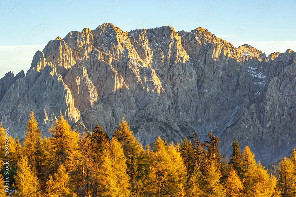 Mountain peak and larch trees at autumn