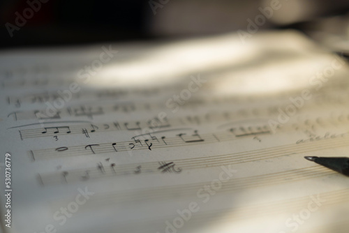 Background of musical notes: score for piano, close-up. Sheet with music notes and pencil. Conservatory, music, sheet music, music lessons, artistic life concept