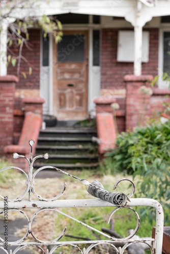 Melbourne, Victoria / Australia - April 29 2020: Front view of old house entrance with focus on foreground. Moonee Ponds suburb City of Moonee Valley.  Abandoned property concept. Old newspaper rolled photo