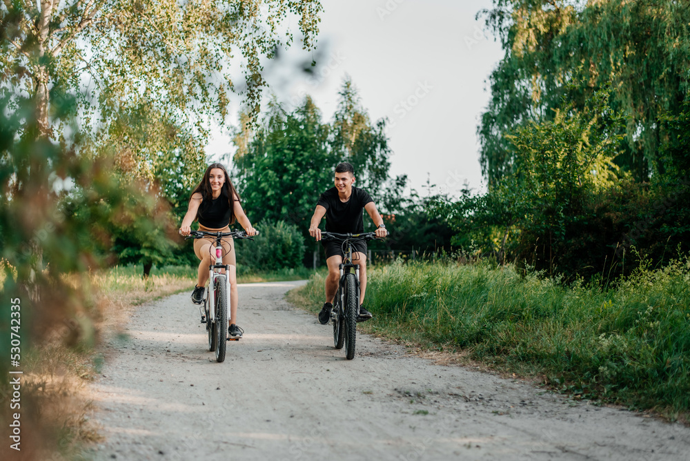 Happy couple cycling outside, healthy lifestyle fun concept