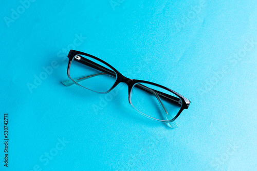 Top view round black Eye Glasses on blue Background