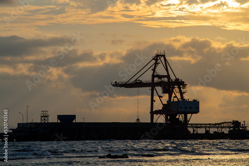 Heavy equipment crane silhouette on twilight clouds background © OYeah