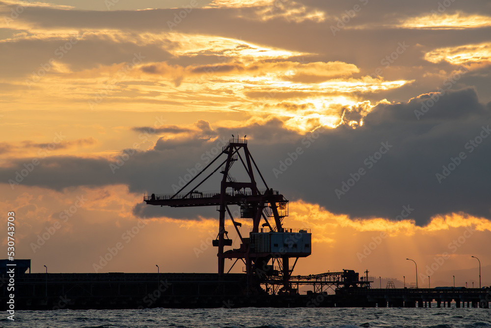 Heavy equipment crane silhouette on twilight clouds background