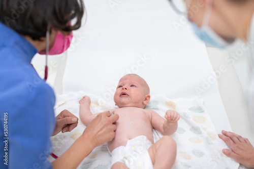 Baby lying on his back as his doctor examines him during a standard medical checkup