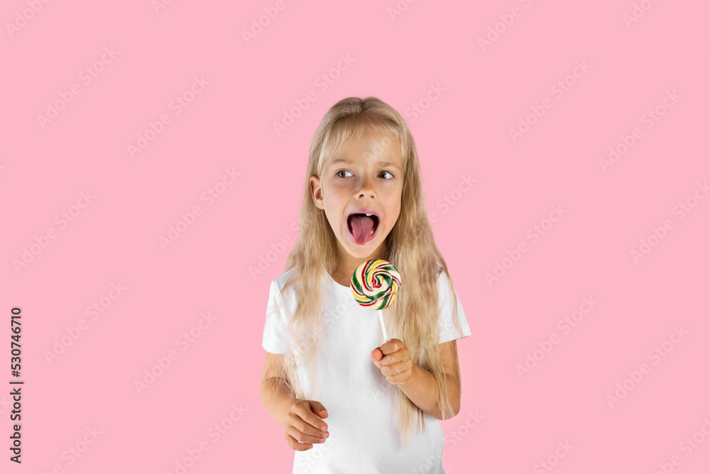 Beautiful girl with a lollipop on a pink background. Beautiful girl with a lollipop on a pink background.