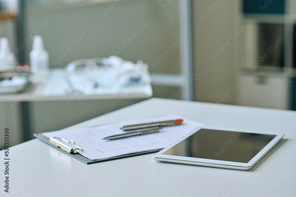 Close-up of digital tablet with medical card lying on table of doctor at office Close-up of digital tablet with medical card lying on table of doctor at office
