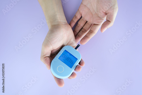 hand of people check diabetes and high blood glucose monitor with digital pressure gauge. Healthcare and Medical concept.