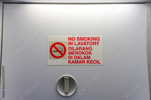 No smoking in the lavatory in the airplane. Dilarang merokok didalam kamar kecil photo
