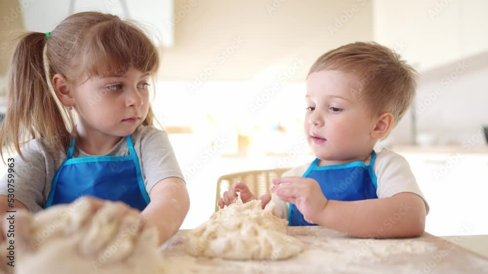children making dough in the kitchen. baby boy cook in the kitchen knead dough and flour indoors. happy family kid dream concept. children play cooking dough lifestyle together at home children making dough in the kitchen. baby boy cook in the kitchen knead dough and flour indoors. happy family kid dream concept. children play cooking dough lifestyle together at home