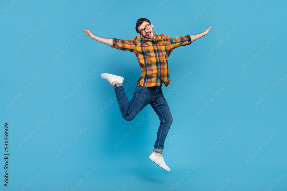 Full length photo of crazy energetic person arms wings fly jump isolated on blue color background