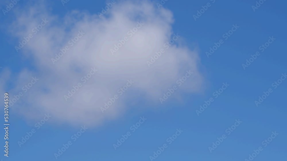 A single fluffy cumulus cloud crosses a blue sky A single fluffy cumulus cloud crosses a blue sky