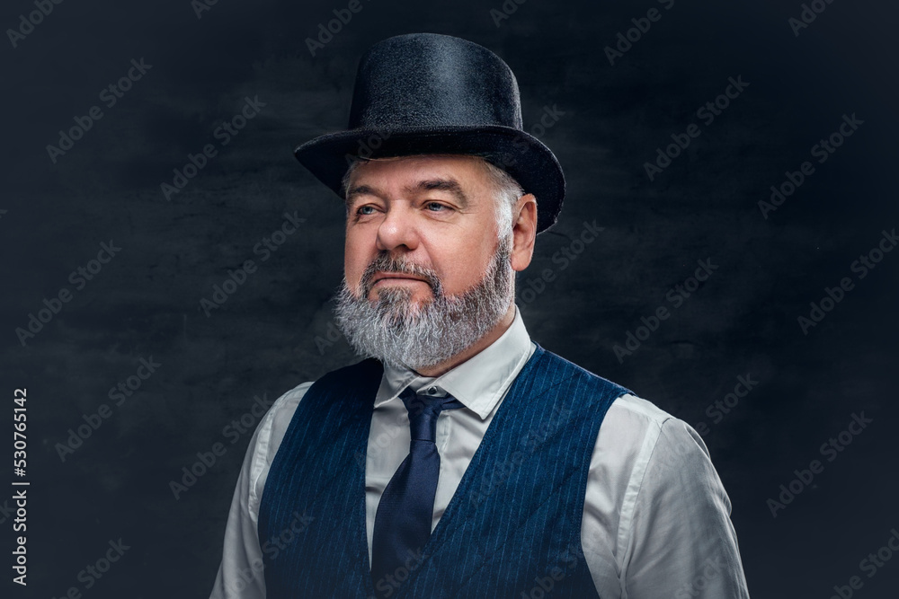 Shot of bearded hipster grandfather dressed in old fashioned costume against dark background.