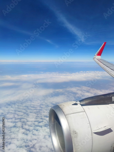 Airplane Wing through the window aircraft during flight with a blue Sky.