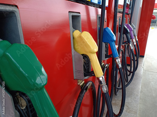 fuel dispenser. The red fuel nozzles are arranged in several colors. Gasoline and diesel service stations. The red fuel dispenser is installed in the red oil dispenser.