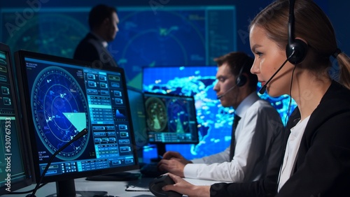 Workplace of the air traffic controllers in the control tower. Team of professional aircraft control officers works using radar, computer navigation and digital maps. Aviation concept.