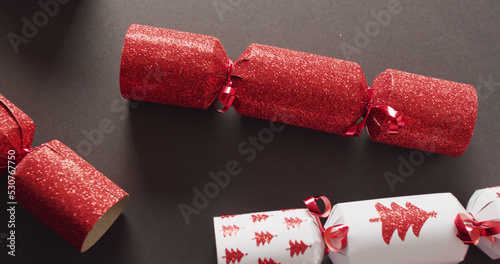 Image of red and white christmas crackers on grey background