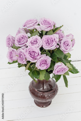 bouquet of beautiful pink roses with water drops in a vase on a white background