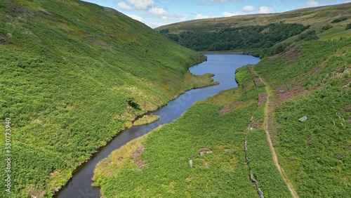 Aerial Drone footage of Yorkshire countryside with valleys moorland and reservoir lake, water. Looking down the valley towards Marsden Village Huddersfield. photo