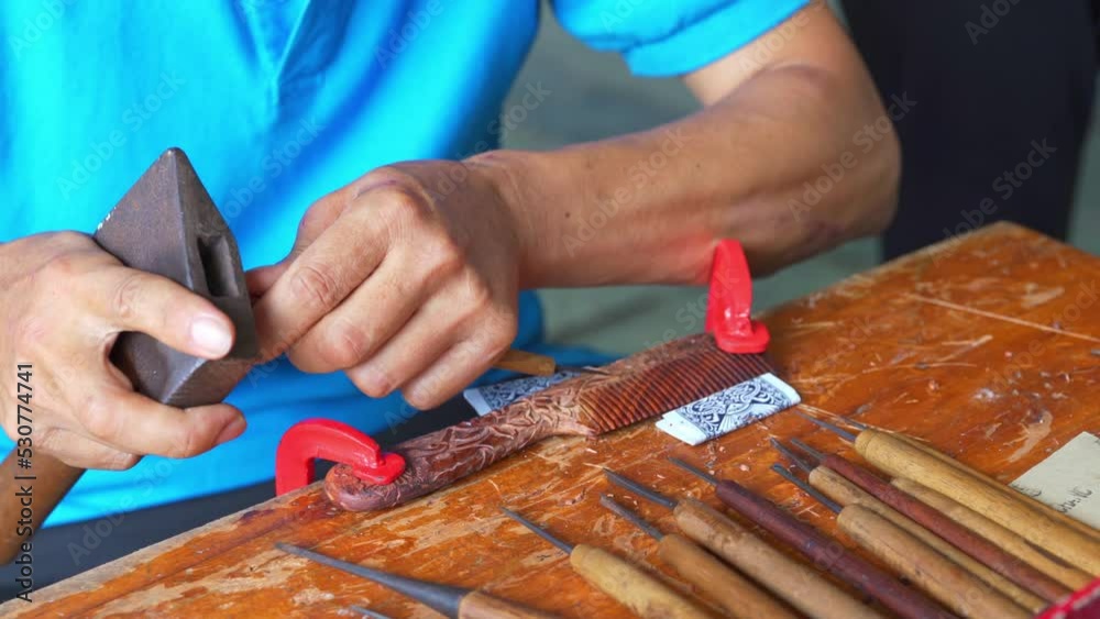 A botched artisan is carving a comb A botched artisan is carving a comb