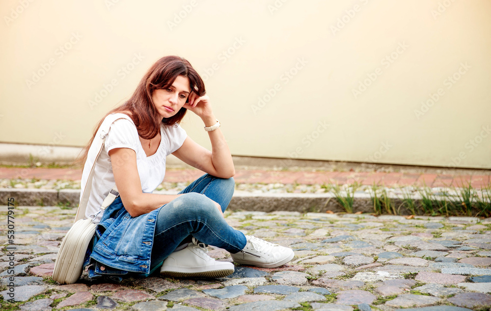 A sad and tired young woman sits on a stone road, she props her head with her hands, a frustrated woman is tired of everyday life and life, she wants rest and happiness.
A sad and tired young woman sits on a stone road, she props her head with her hands, a frustrated woman is tired of everyday life and life, she wants rest and happiness.