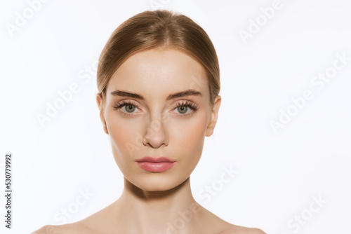 Closeup portrait of beautiful young girl with clean well-kept skin isolated over white background. Skin care. Facial treatment. Cosmetology, beauty and spa.