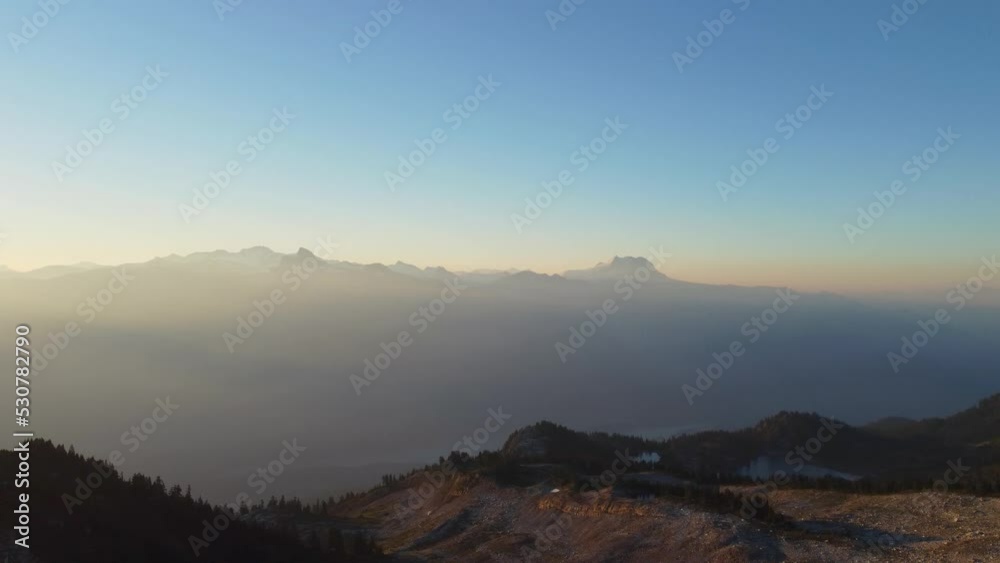 Sunset Aerial Drone Panning to Reveal Sun Flare Over Hazy Rocky Mountain Landscape with Pine Trees 4K Sunset Aerial Drone Panning to Reveal Sun Flare Over Hazy Rocky Mountain Landscape with Pine Trees 4K