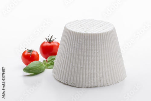 whole ricotta with fresh tomato on a white background