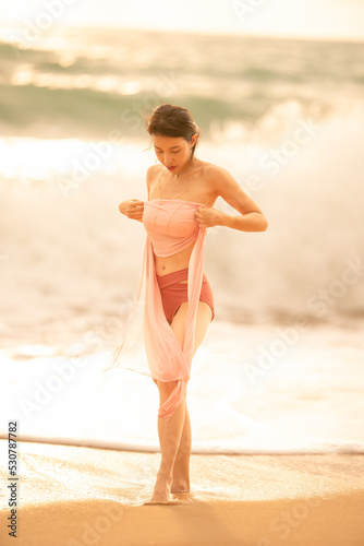 Fototapeta Naklejka Na Ścianę i Meble -  Woman in sexy swimwear posing on the tropical beach in sunset light.