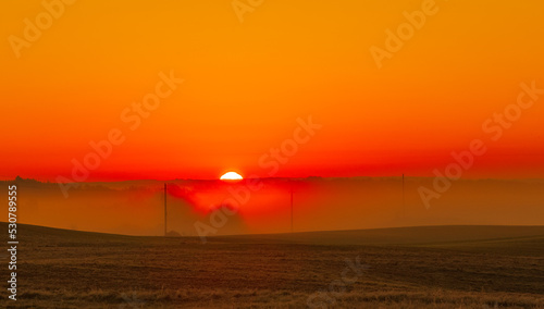 Sunrise, heat and hot weather, orange landscape with sun © lukjonis