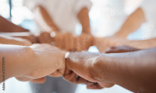 Hands  teamwork and motivation with a team of business people joining their fists in a huddle or circle. Collaboration  goal and target with a group of staff in their office for unity and success