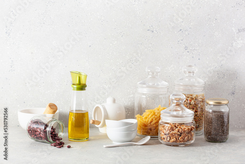 kitchen utensils on modern simple counter, kitchenware jars with dry ingredients bowls