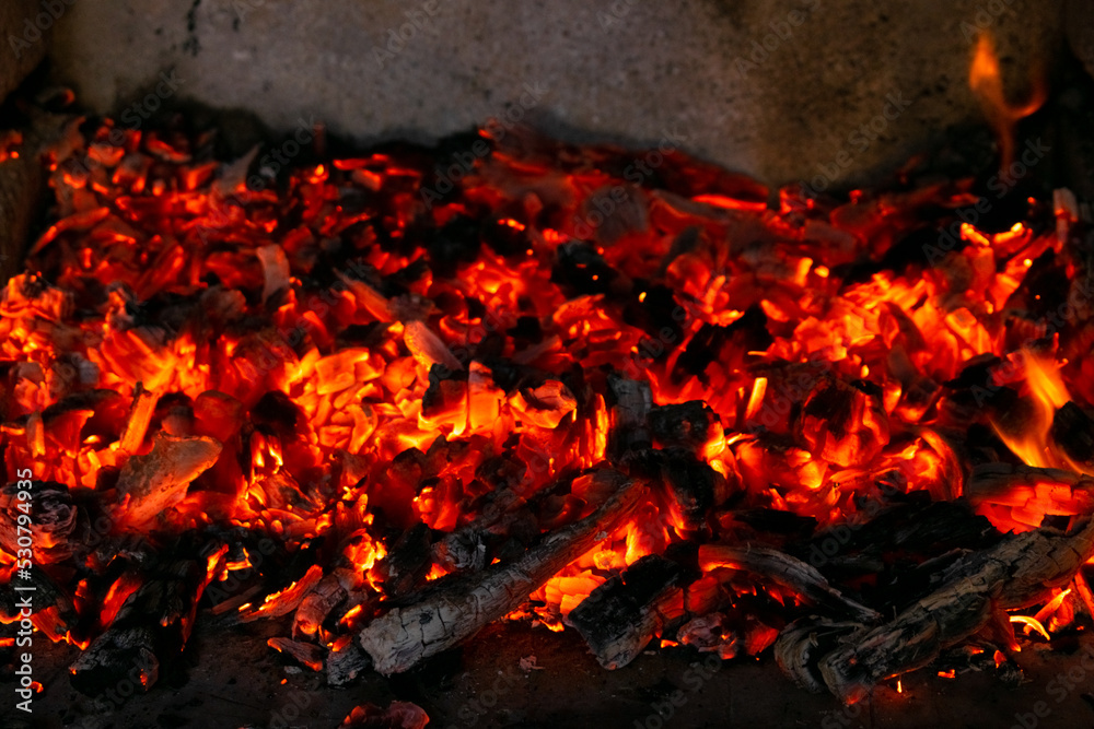 Burning coals in the fire. Wood embers burn with red fire at high temperature Burning coals in the fire. Wood embers burn with red fire at high temperature