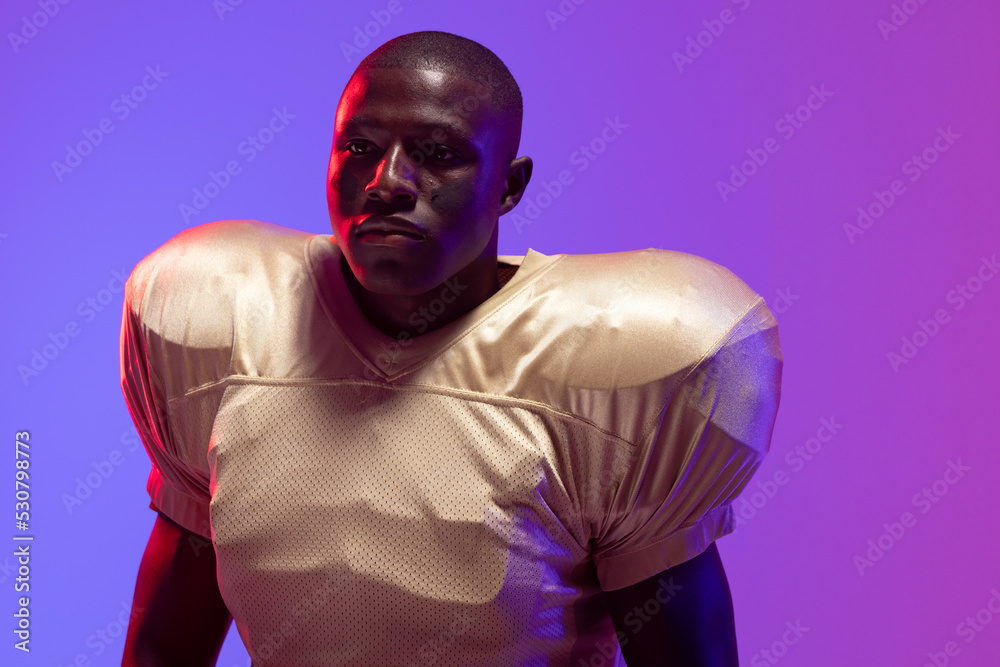 African american male american football player with neon blue and purple lighting