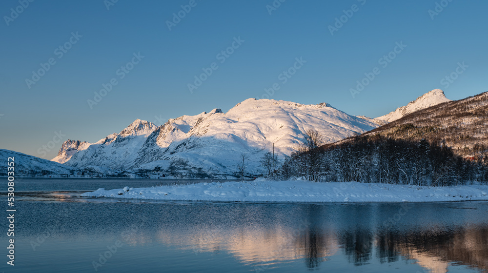 Sunset over the Norwegian fjord, winter photos at the golden hour, Tromso, Norway
