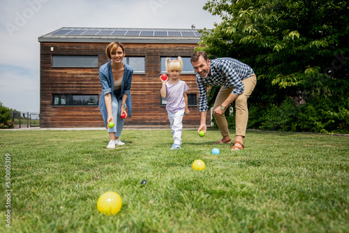 Family playing petanque in their backyard spending happy moments together photo
