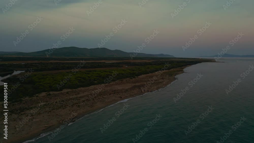 Flying over Maremma National Park beach with panoramic evening sunset sky in Tuscany, Italy. Cinematic aerial drone footage of seaside coast and pine tree forest with an island in the distance. 4K Flying over Maremma National Park beach with panoramic evening sunset sky in Tuscany, Italy. Cinematic aerial drone footage of seaside coast and pine tree forest with an island in the distance. 4K